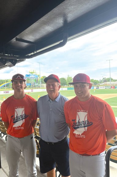 Neil Sullivan (left) and Brody Huff (right) spend time with Eagle head coach David Bradshaw during the IHSBCA Futures event.