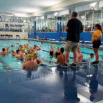 The Milan Aquatics swim program goes over some last minute instructions prior to the SEISA Championships last week. Milan won six titles at the event and finished runner-up as a team.