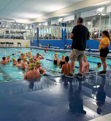 The Milan Aquatics swim program goes over some last minute instructions prior to the SEISA Championships last week. Milan won six titles at the event and finished runner-up as a team.